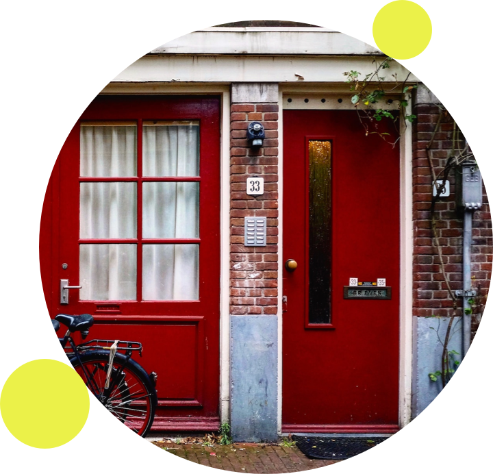 een huis met een rode voordeur en een fiets ervoor